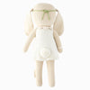 Cuddle + Kind Hannah the Bunny is a beige hand-knit doll made from premium cotton yarn, featuring a white dress, fluffy tail, and green headband, shown from the back on a white background.