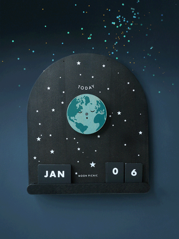 The Me & The Moon – Moon Phase Calendar features a rotating Earth, magnetic moon discs, and star details. “Today,” “JAN,” and “06” are displayed amid confetti-like accents, giving this wooden calendar a celestial, space-inspired feel.