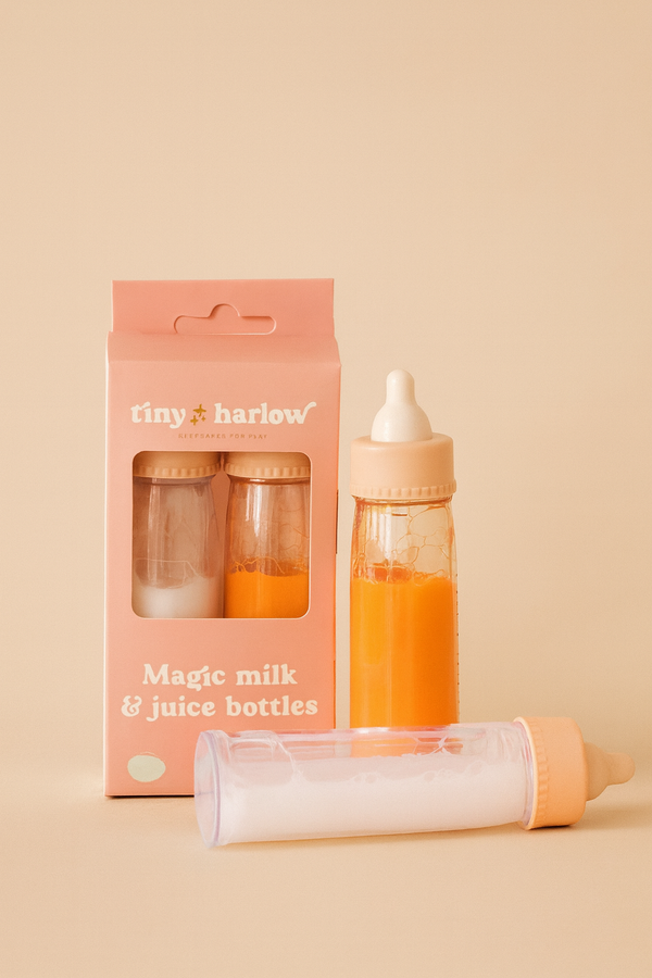 The Tiny Harlow Bottled Milk and Juice Set features two magic bottles—one with “milk,” one with “juice”—next to a pink box labeled “tiny harlow Magic milk & juice bottles,” all displayed on a soft beige background. Perfect for doll feeding play!.