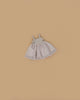 The Minikane Doll Clothing | Rosella Tutu - Pink, a small sleeveless light pink dress with a fitted bodice and flared skirt, designed in France for Minikane dolls, is laid flat on a plain beige background.