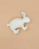 A soft Senger Naturwelt Cuddly Animal - White Bunny with closed eyes lies on its side against a plain beige background, evoking cozy charm.