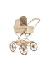 The Doll Pram - Fleur Decor, with its vintage charm reminiscent of a classic baby carriage, features a beige floral-patterned fabric. It is equipped with large spoked wheels and a curved handle, providing ample space that includes an organic cotton mattress. The partially raised hood offers a glimpse of the blue blanket inside. This product ships in approximately two weeks.