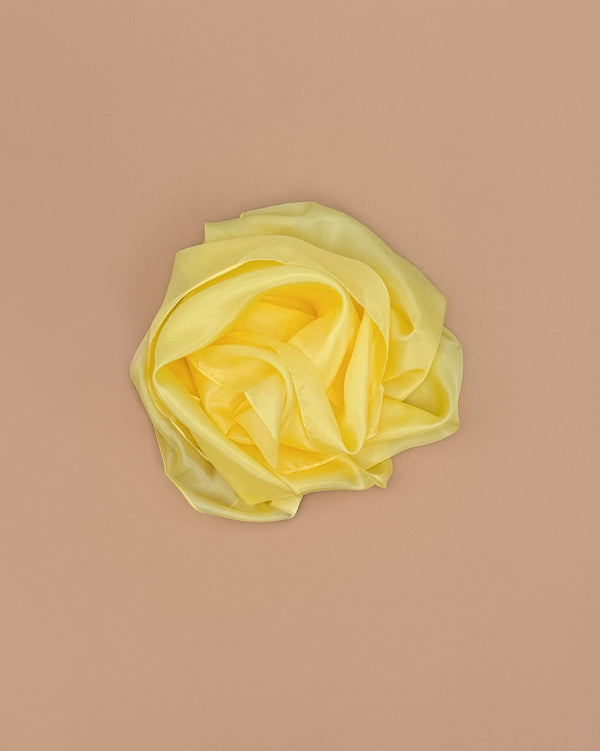 The Sarah's Silks Solid Color Playsilk - Sunshine, made from 100% pure yellow silk and artfully shaped like a rose on a beige background, is perfect for open-ended play.