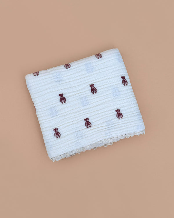 The Organic Cotton Layered Gauze Pillowcase - Teddy, featuring small brown teddy bears, is folded neatly and displayed on a plain beige background.
