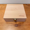 The Toverlux Silhouette Storage Box Deluxe is a light wooden box with a gold-colored latch, featuring "TOVERLUX" and stars engraved on the lid—perfect for organizing your Toverlux Silhouettes.