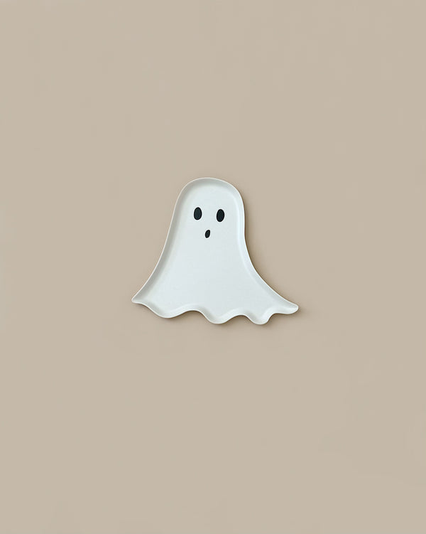 A small, white Meri Meri Reusable Bamboo Ghost Plate with two black eyes and an open mouth against a beige background, perfect for Halloween parties.