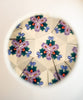 View through the Konges Sloejd Kaleidoscope - Like Cats and Dogs reveals a symmetrical, geometric pattern with purple, green, blue, and red shapes reflected in a circular frame—reminiscent of colorful pearls shimmering inside its FSC-certified design.