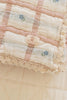 A close-up of the Organic Cotton Baby Quilt - Meadow, Petal: a soft, pastel quilt with delicate lace edges, blue floral patterns, and a "NEW BRAIN" tag. This cozy 30x40 inch vintage-style quilt is made in Portugal from organic cotton.