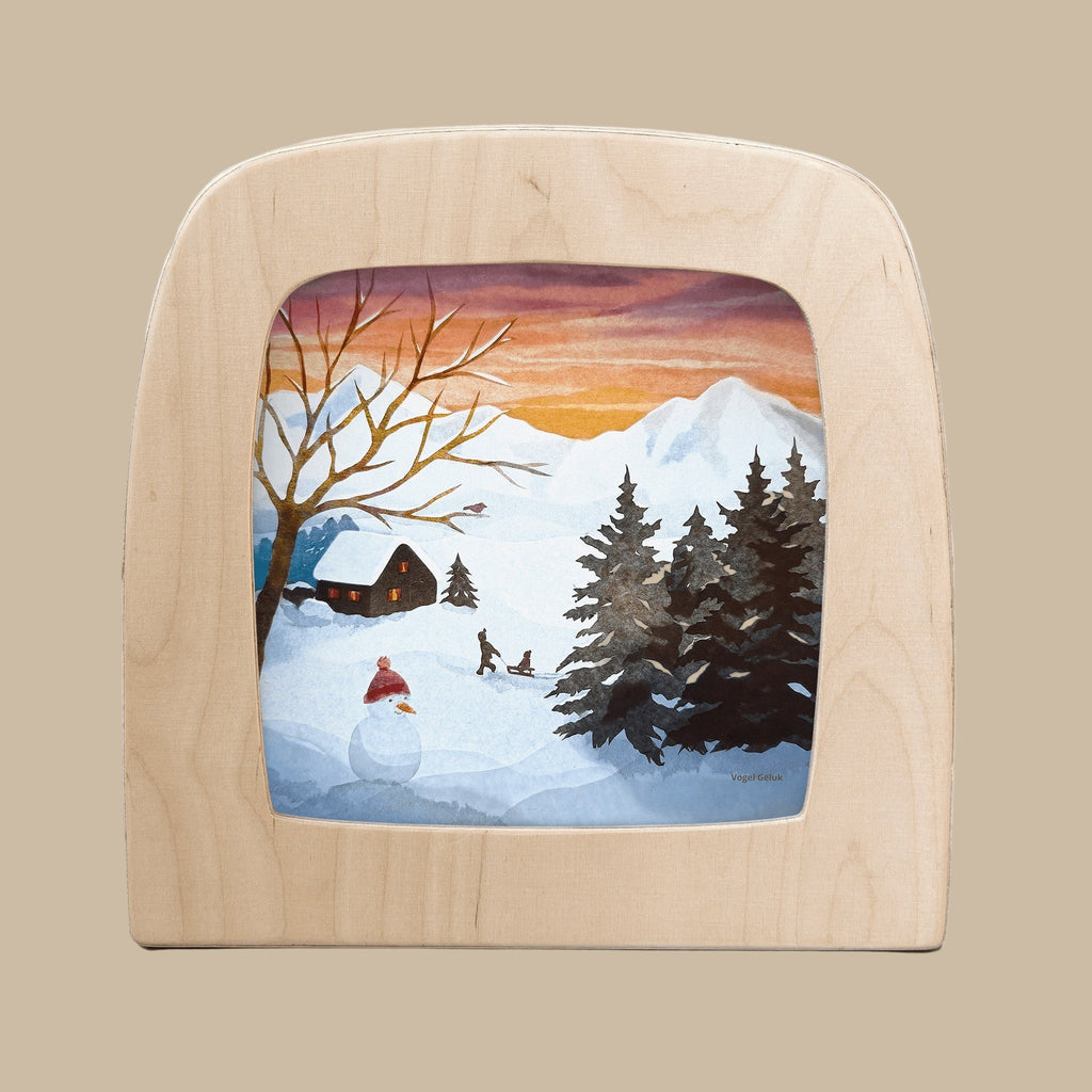 The "Silhouette Only - Sled Song for Toverlux Lamp" showcases a translucent winter scene with snowy mountains, a cabin, pine trees, and two people sledding at sunset—perfect as charming home decor.