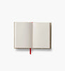 A Schoolhouse Mini Embroidered Journal with unlined pages and a red ribbon bookmark lies open and flat on a white background.
