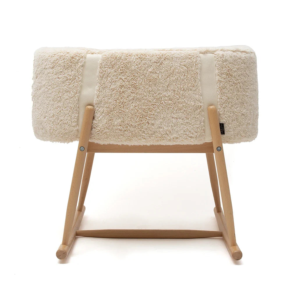 A small, soft rectangular stool with a beige fluffy cushion and light wooden legs in modern minimalist style—perfect for pairing with the Charlie Crane KUKO 'Fur' Moses Basket to add a cozy touch to any nursery.