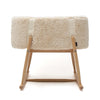 A small, soft rectangular stool with a beige fluffy cushion and light wooden legs in modern minimalist style—perfect for pairing with the Charlie Crane KUKO 'Fur' Moses Basket to add a cozy touch to any nursery.