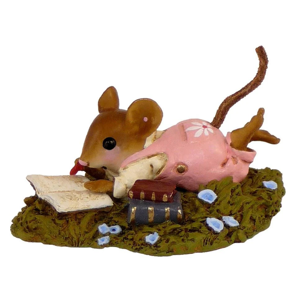 Meadow Musing is a Wee Forest Folk hand-painted mouse figurine in a pink dress, lying on its stomach with an open book, blue flowers, and stacked books—a delightful collectible for miniature enthusiasts.