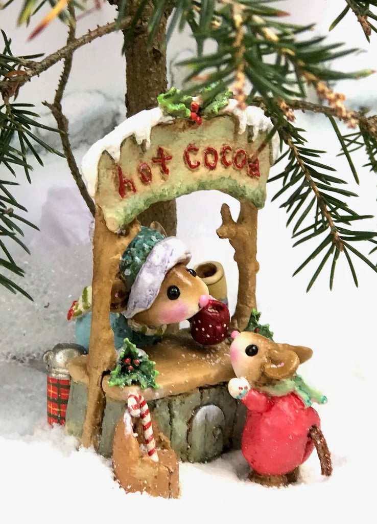 The Wee Forest Folk Tiny Collectible - Hot Cocoa Comin' Up! (Not a Toy) features two hand-sculpted mice in winter clothes at a "hot cocoa" stand under a snowy branch, with mugs, gifts, and charming snowy details.