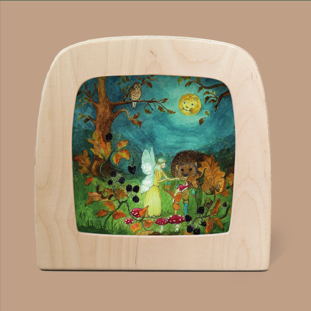 A framed artwork titled "Autumn Pixie - Silhouette Only" captures a whimsical scene featuring a fairy and a hedgehog playing instruments in an enchanting forest. Ethereal silhouettes of an owl and the moon cast a magical glow as they peek through the trees, surrounded by vibrant plants and berries. This piece ships in approximately one week.