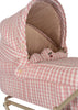 A close-up of the Konges Sloejd Doll Pram in Powder Pink Checkers, showcasing its pink and white checkered pattern with cherry embroidery details inside. The pram features quilted fabric, a padded mattress with a beige interior, and is mounted on a metal stand.