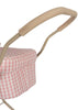 A close-up of the Konges Sloejd Doll Pram's handle reveals a beige foam grip, capturing the enchanting essence of a vintage-style stroller. The pink and white checkered fabric adds a quilted appearance, contributing to its soft and stylish aesthetic. The image emphasizes the handle's intricate craftsmanship.