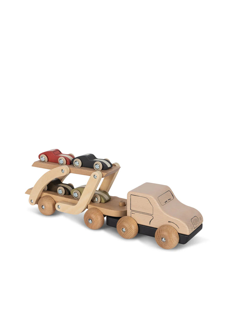 The Konges Sløjd - Wooden Car Transporter is crafted from FSC-certified beech wood and includes a truck cab with trailer, along with three race cars in red, black, and green. Featuring a minimalist design with natural wood tones and movable parts, it embodies both style and functionality.