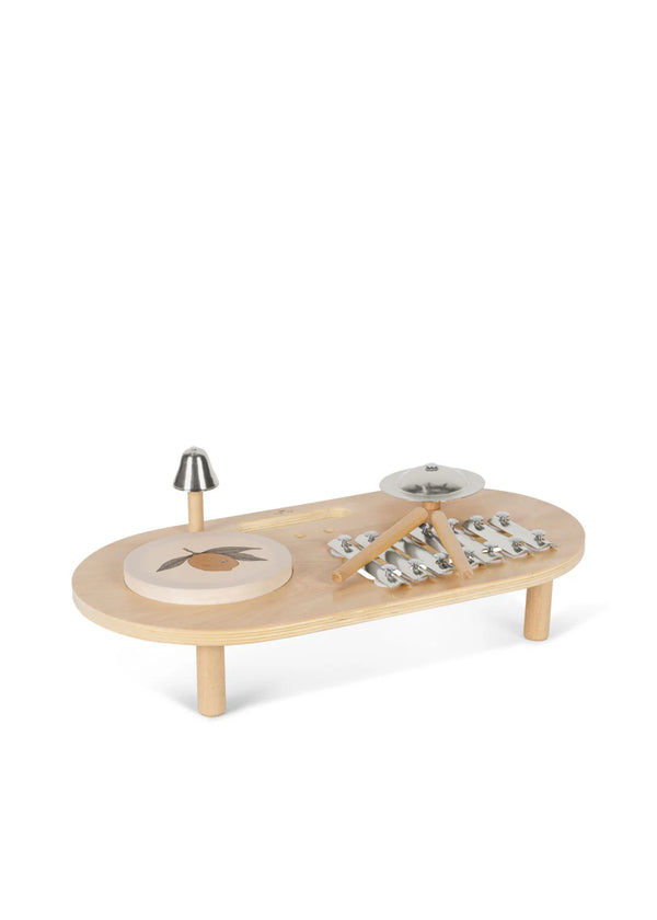 The Konges Sløjd - Wooden Music Board is crafted from FSC-certified plywood and features a small drum, a xylophone with metal bars, and a bell. It comes with two wooden drumsticks resting on the xylophone and is supported by four short legs, making it ideal for young musicians to explore sounds.