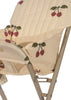 Here's a revised version of the sentence using the given product data:

A close-up of the Konges Sloejd High Chair - Cherry Glitter, showcasing its beige foldable design with a cushioned seat and backrest adorned in a cherry pattern. This high chair is perfect as a doll accessory, featuring a metal frame and intricate fabric stitching.