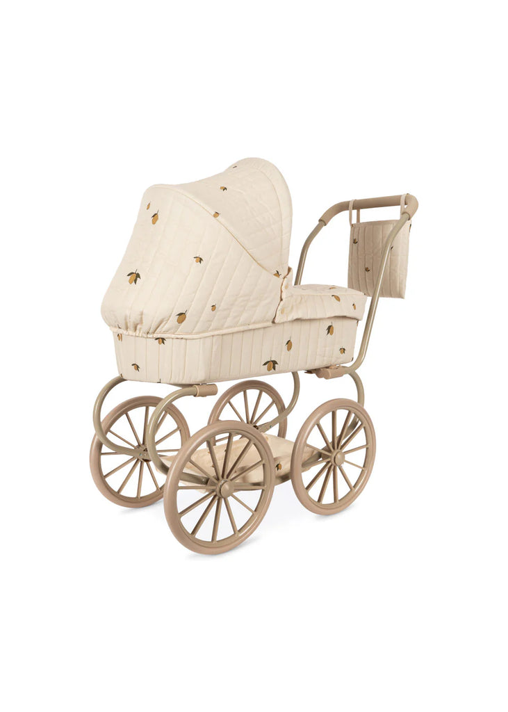 The Konges Sloejd Mini Doll Pram - Lemon is a charming vintage-style pram featuring a beige quilted fabric canopy adorned with small decorative patterns. It comes with large brown wheels, a sturdy metal frame, and a cushioned storage basket for added convenience. (Ships in approximately one week.)