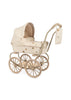 The Konges Sloejd Mini Doll Pram in Lemon features a vintage-style design, complete with a quilted cream canopy and basket adorned with a delicate floral pattern. It boasts large beige wheels, a coordinating handlebar, and a cushioned storage basket. A charming small bag is elegantly suspended from the handle. (Ships in approximately one week.)