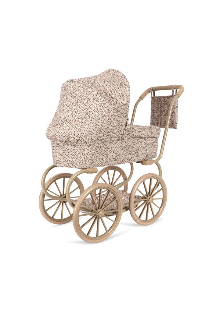 Introducing the Konges Sloejd Mini Doll Pram - Milk Tank: a charming baby stroller with large wheels and a floral-patterned quilted fabric cover, featuring a beige and brown color scheme. This delightful pram includes a matching canopy and a cushioned storage basket on the handle, evoking the essence of vintage-style doll prams.