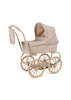 The Konges Sloejd Mini Doll Pram - Milk Tank is a vintage-style doll pram, crafted with quilted floral fabric and equipped with four large spoked wheels. It includes a matching detachable bag hanging from the handle, and the raised canopy enhances its charm. Additionally, it features a cushioned storage basket for practical storage solutions.