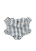 A baby romper in blue and white gingham with ruffled sleeves and an embroidered cherry on the chest, shown next to the Konges Sloejd Doll Carrier - Blue Checkers, all set against a plain white background.
