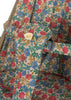 Close-up of the Konges Sloejd Doll Stroller - Fiola seat featuring a red, blue, and yellow Fiola print, with a small yellow fabric rose attached to the seat strap.