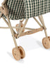 Close-up of the lower part of the Konges Sloejd Doll Stroller - Smoke Pine Checker, featuring beige plastic double wheels, a sturdy frame, and a green and white checkered fabric seat.