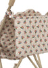 The Konges Sloejd Doll Stroller - Verona Blues features a close-up of its red, blue, and green floral-print carriage bag on beige fabric, draped over the handle of a beige metal doll stroller with double wheels.