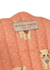 Close-up of quilted pink fabric with white polka dots, illustrated with adorable kittens. The fabric label displays “KONGES SLOJD” and “cherry on top,” accented by small cherry graphics. The Konges Sloejd Doll Stroller - Ciao Miao Rose is perfect for a doll stroller or carriage bag, adding a playful and charming touch to any outing.