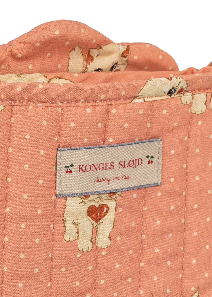The Konges Sloejd Doll Stroller - Ciao Miao Rose showcases a quilted peach-colored fabric with white polka dots and adorable printed kittens. Ideal for decorating a doll stroller, this delightful textile features a label reading “Konges Sløjd” accompanied by small cherry icons and the phrase “cherry on top.”.