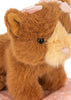 A close-up of the Konges Sloejd Take Care of Me Animals - Cat, featuring a brown and beige plush kitten with a pink bow on its head, sitting on a pink fabric with white polka dots. This adorable mini toy is perfect for any collection from the ‘Take Care of Me’ series.
