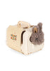 A soft brown bunny from the Konges Sloejd Take Care of Me Animals – Bunny collection peeks out from a petite cream-colored toy pet carrier with a handle and dotted door, inviting you to nurture and play.