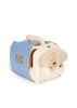 A mini Konges Sloejd Take Care of Me Animals Dog plush peeks out from a small cream-colored plastic pet carrier with a blue polka dot cover and handle, ready for you to care for it.