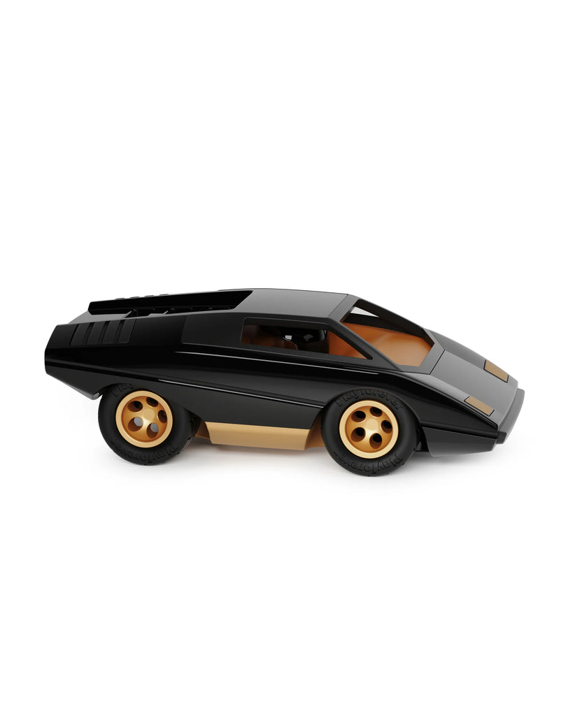 The Playforeer UFO Cannone Car in Black features gold accents and wheels, a low angular 70s-inspired Italian design, and is displayed in side profile against a white background.
