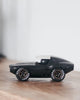 A Playforever Leadbelly Skeeter Car in Black, featuring a white roof and "SUNRAY" on its tires, sits on a wooden surface against a plain, light background.