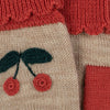 A close-up of a Sonja Knit Mittens - Beige Melange featuring a cherry design with red fruits and green leaves on a beige background, bordered by a textured red section made of mulesing-free merino wool.