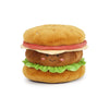 The MON AMI Joe Burger Plush Toy features a smiling face, rosy cheeks, green lettuce, brown patty, yellow bun, and pink felt tomato—all from soft materials—on a white background. This adorable plush is perfect for snuggles.