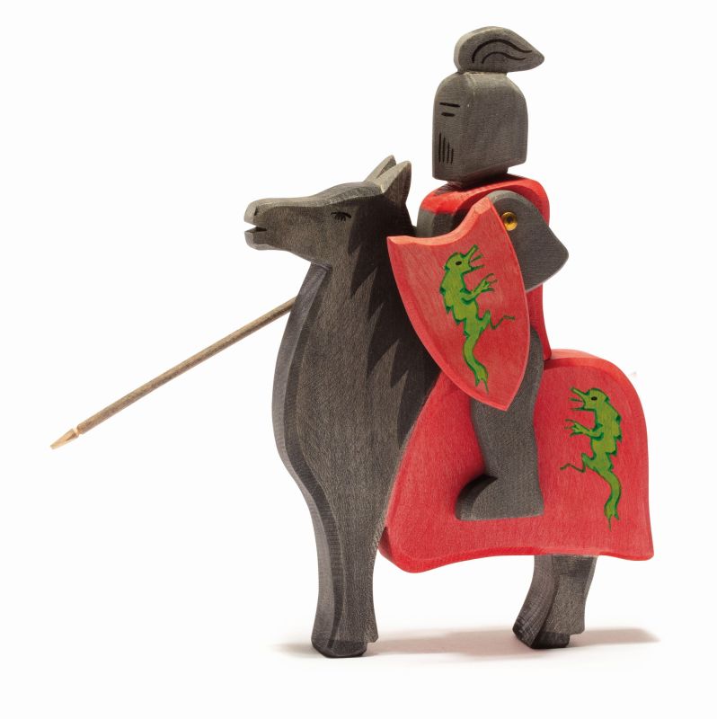 An intricately crafted wooden knight in black armor rides atop the Ostheimer Horse for Black Knight, clutching a lance and bearing a red shield emblazoned with a green dragon emblem. The horse is similarly adorned with a matching red cover featuring the same emblem, ensuring endless imaginative play. This exquisite set exemplifies the unparalleled quality of Ostheimer toys.