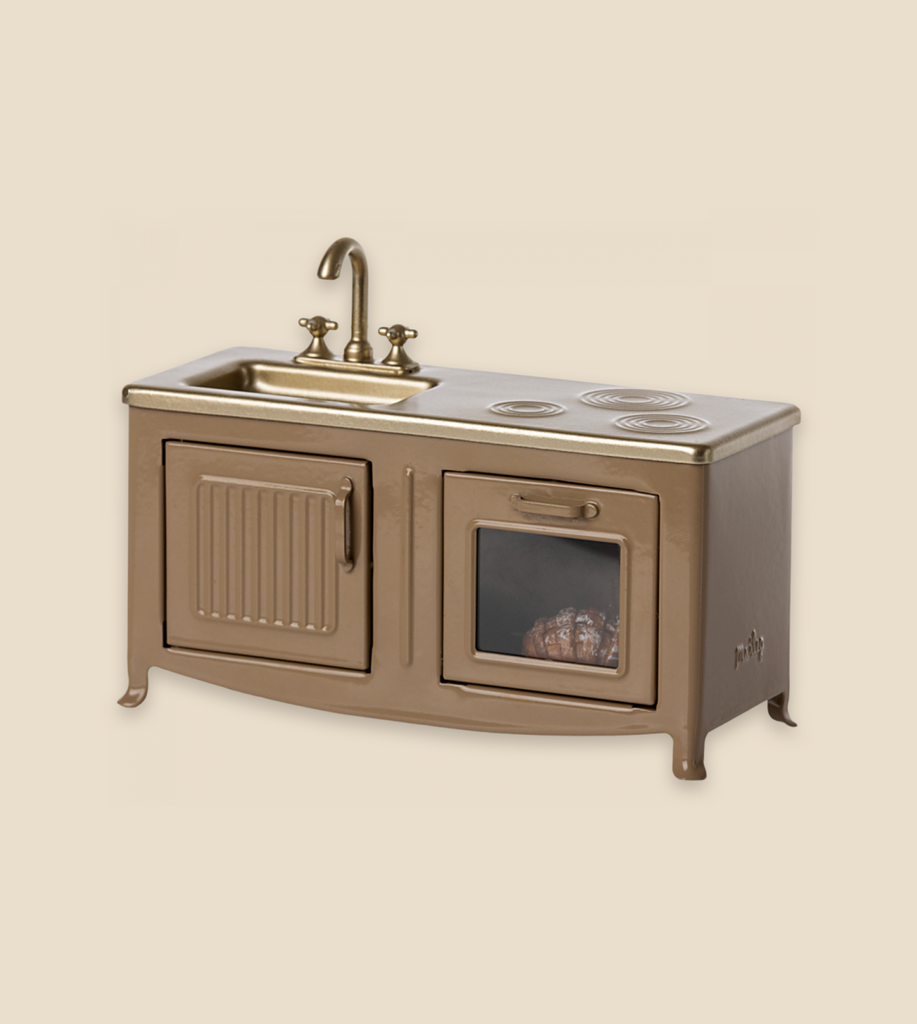 A Maileg Kitchen - Light Brown featuring a sink, faucet, and an integrated oven with a visible window, set against a plain background and incorporating metal kitchen accents.