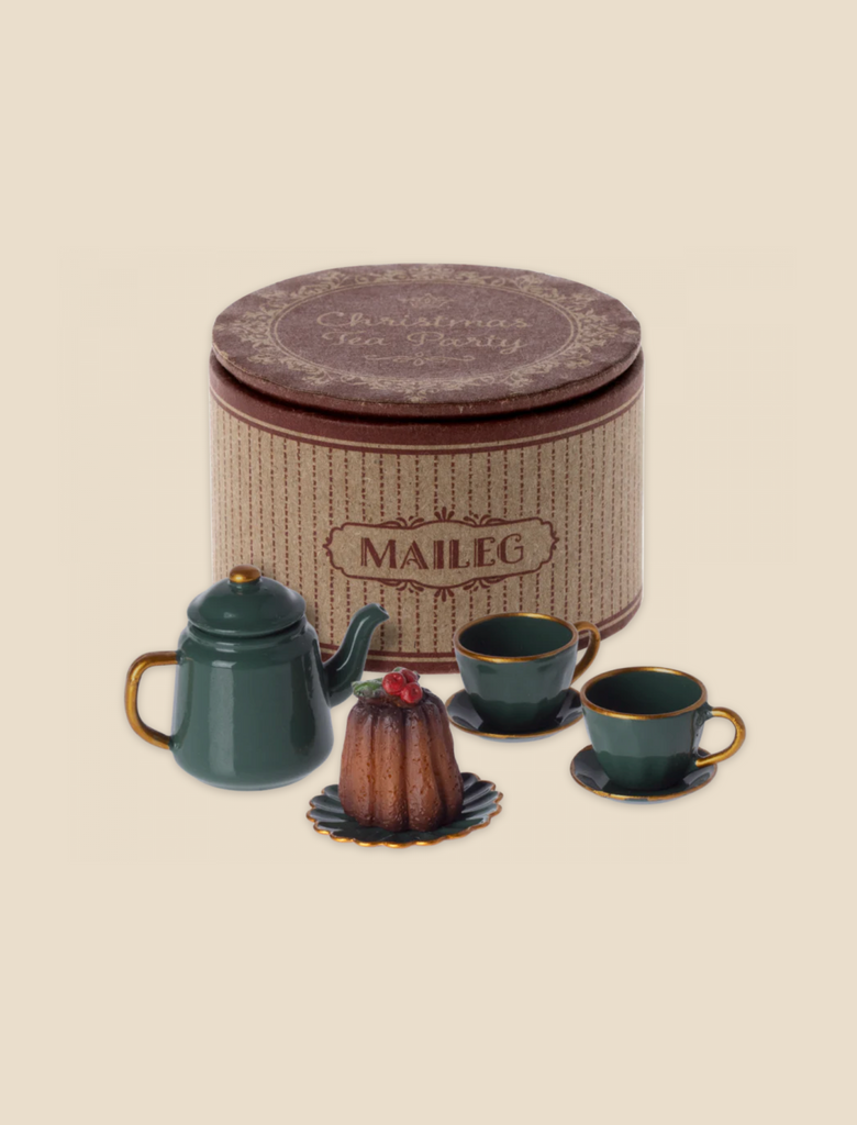 A Maileg Christmas Tea Party featuring a green metal teapot, two green teacups with saucers, and a small cake on a plate is displayed in front of a round vintage-style cardboard box labeled "Maileg" with the phrase "Christmas Tea Party" on the lid—everything perfect for mouse family size gatherings.