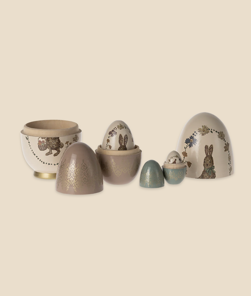 A collection of Maileg Easter Babushka Eggs, 5 pcs, and a bowl, each intricately designed with floral and bunny patterns, displayed against a soft beige background.