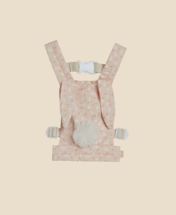 A child's pink harness with a fluffy white tail and a pattern of tiny bunnies, displayed on a soft yellow background, is known as the Olli Ella x Odin Parker Dinkum Dolls Cottontail Carrier – Lapin.