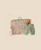 Maileg Little Sister With Clown Outfit: includes a pastel suitcase with "Cirque de l'Amour," green suspenders and pants, and a white party hat with orange pompom—perfectly sized for Maileg Mouse or Matchbox Mouse, shown on a beige background.