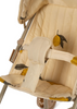 A close-up of the beige seat of the Konges Sloejd Zoe Doll Stroller - Lemon, featuring a cushioned harness and backrest. The removable fabric is adorned with yellow lemon illustrations and green leaves. The partially visible frame, resembling that of a doll stroller, showcases its metal construction and subtle color.