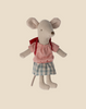 A Maileg Big Sister With Backpack - Red, dressed in a red checkered shirt and blue plaid skirt with a red bow around the neck, stands upright against a beige background. Perfect as a kindergarten toy or an adorable tricycle accessory.