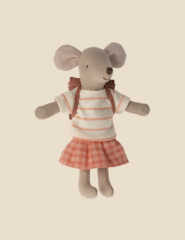 The Maileg Big Sister With Backpack - Coral is wearing a striped shirt and a plaid skirt. The shirt is white with peach stripes, and the skirt is a peach and white plaid pattern. The mouse has large round ears and a small brown nose, with a bow tied around its neck. Perfect for cuddles or to fit in your backpack!